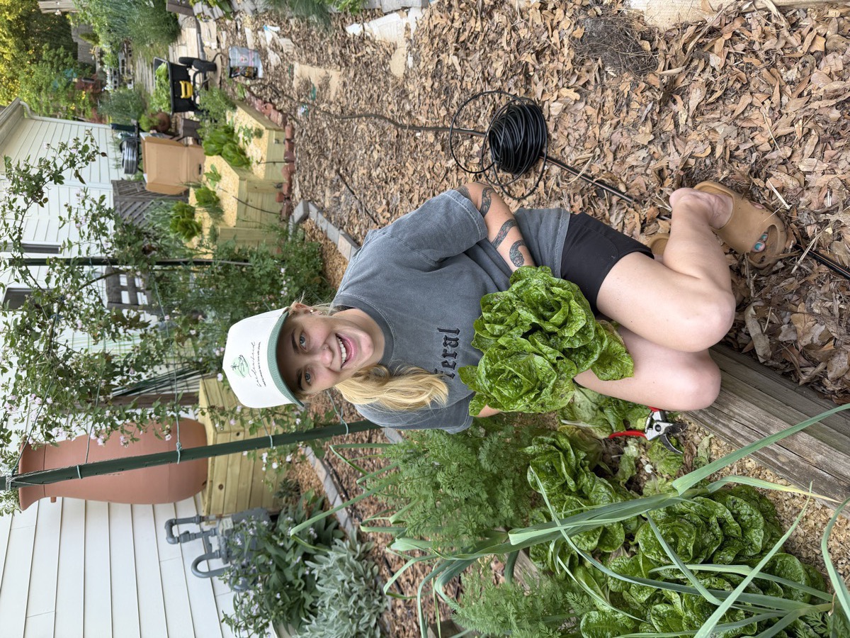 Chelsea in the garden holding a head of lettuce